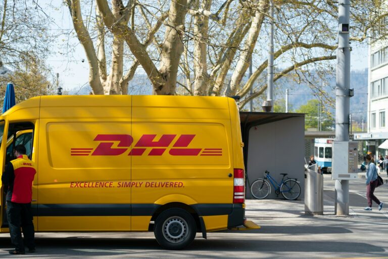 Wem gehört DHL? man standing in front of DHL truck door